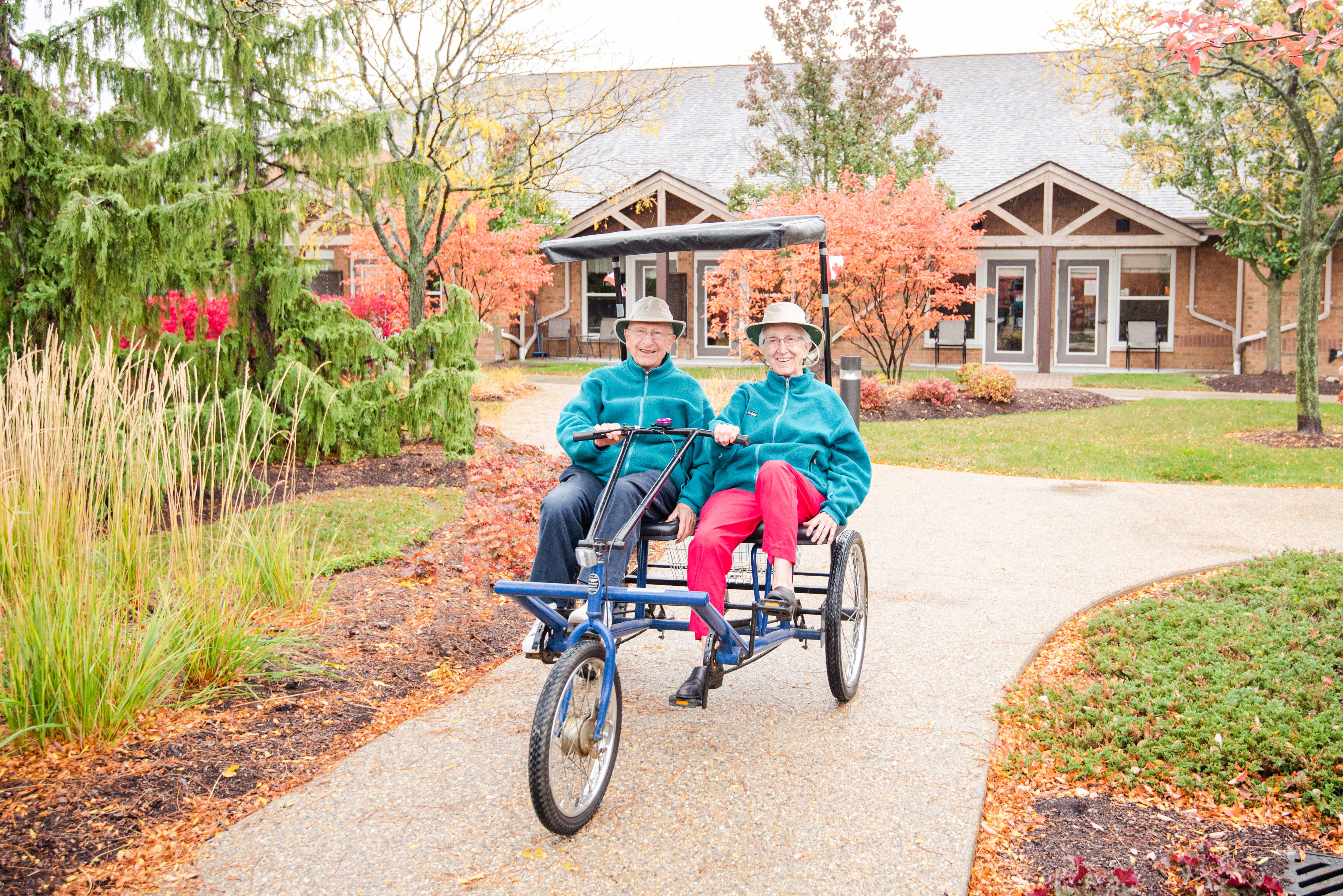 Residents riding a duet bike in the village courtyard