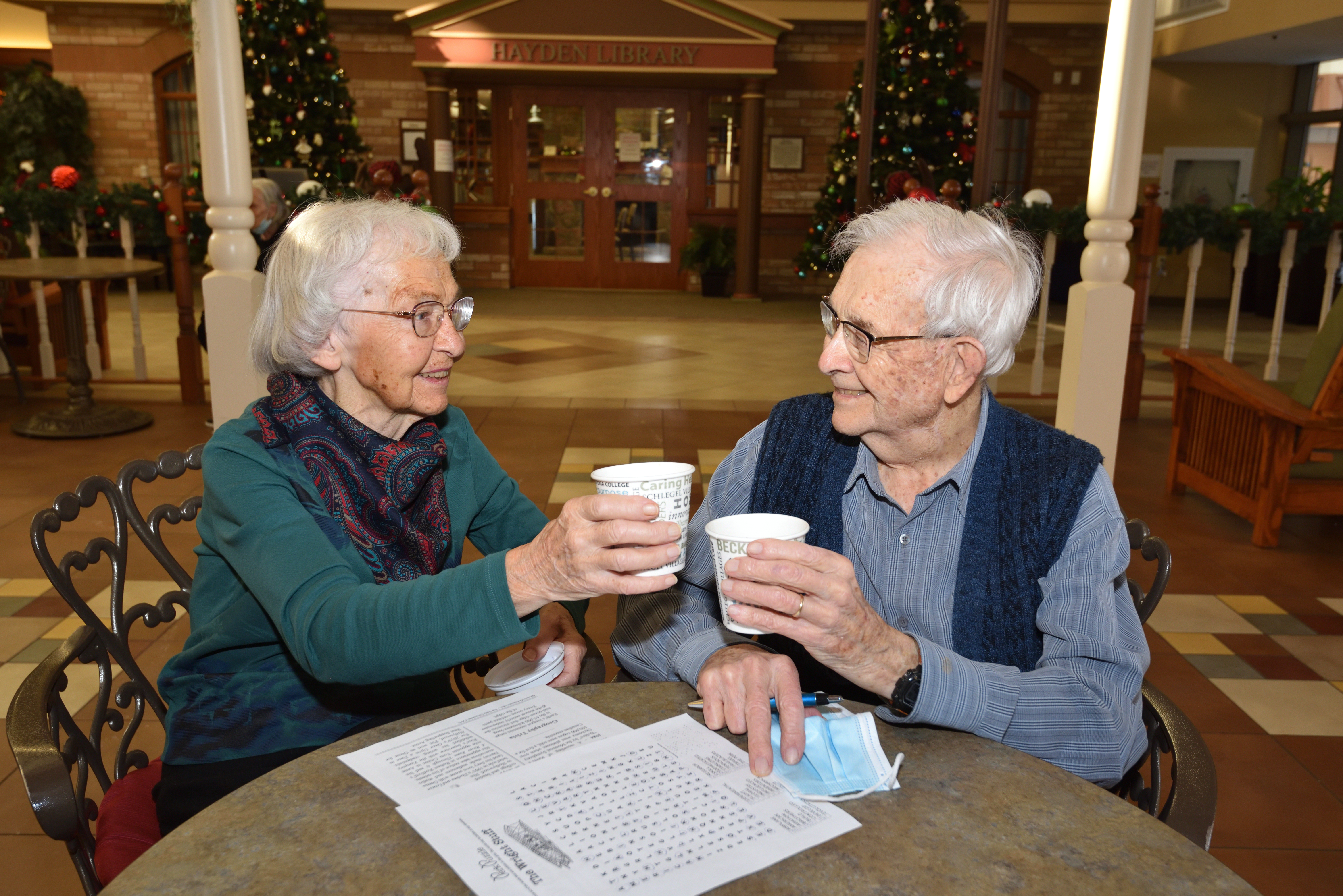 Resident couple cheersing with their coffee in the Cafe