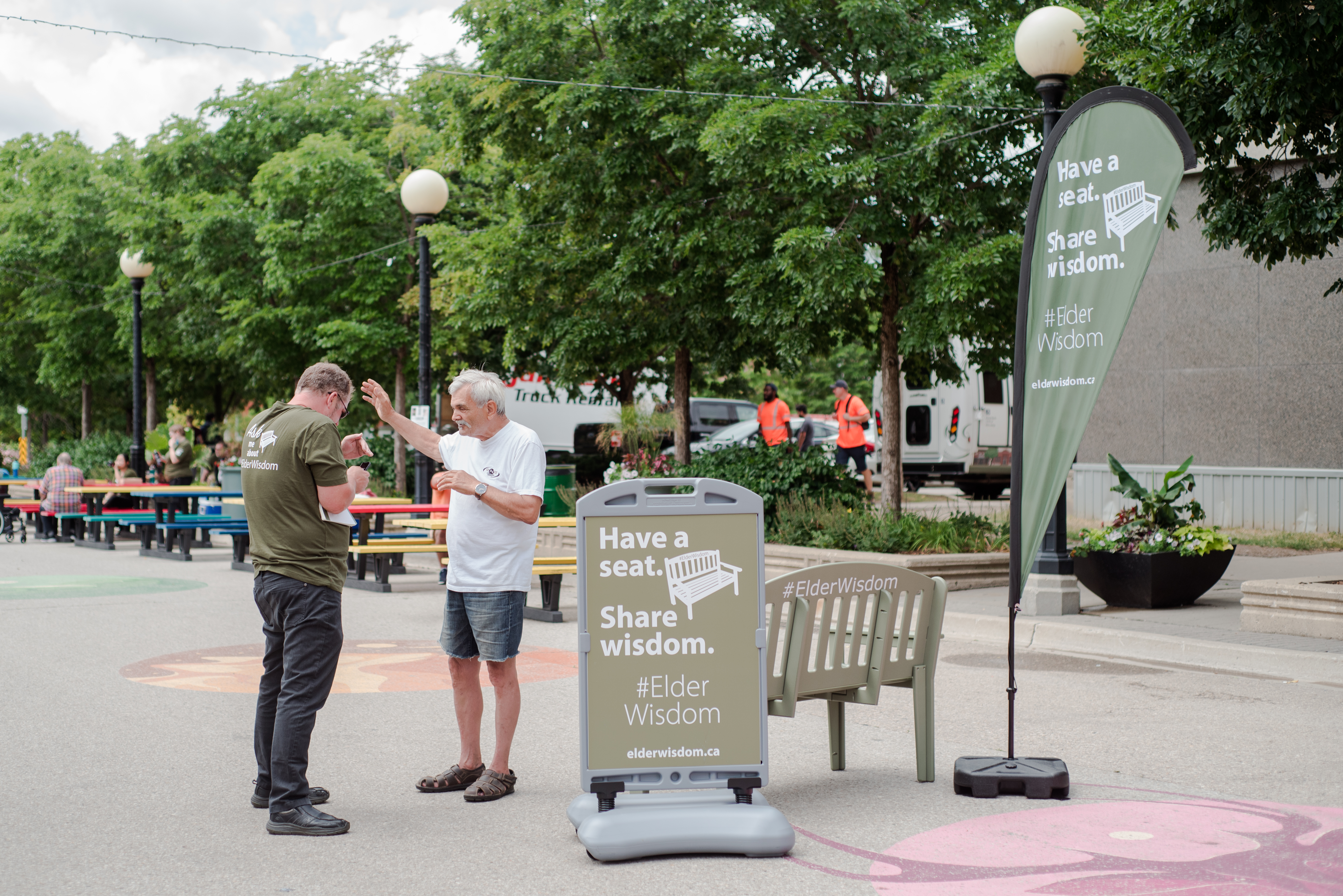 Writer interviews pedestrian at the #ElderWisdom green bench event outdoors