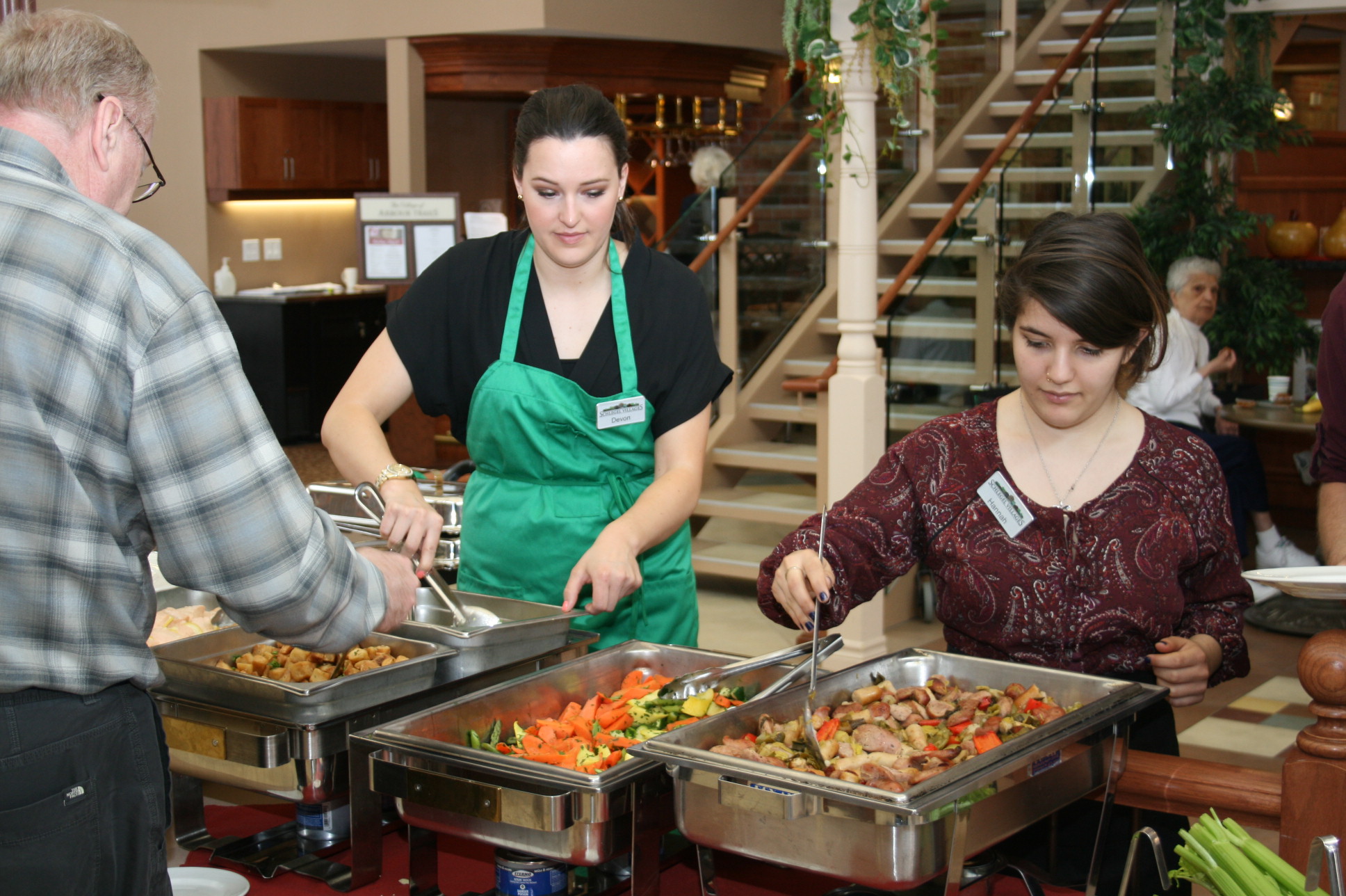 Food service team members serve a special meal at the Village