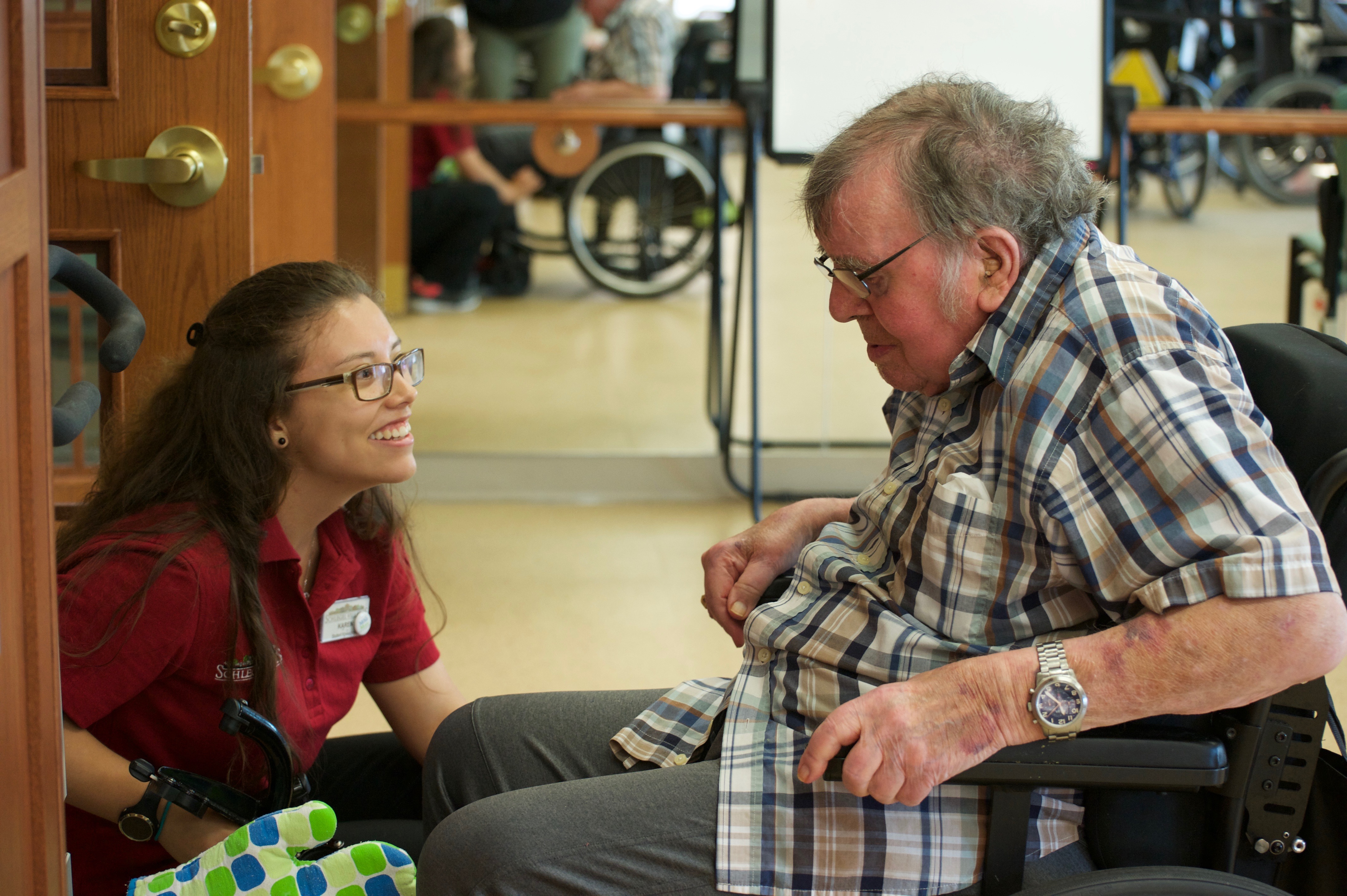Team Member offers quality care to resident in a wheelchair