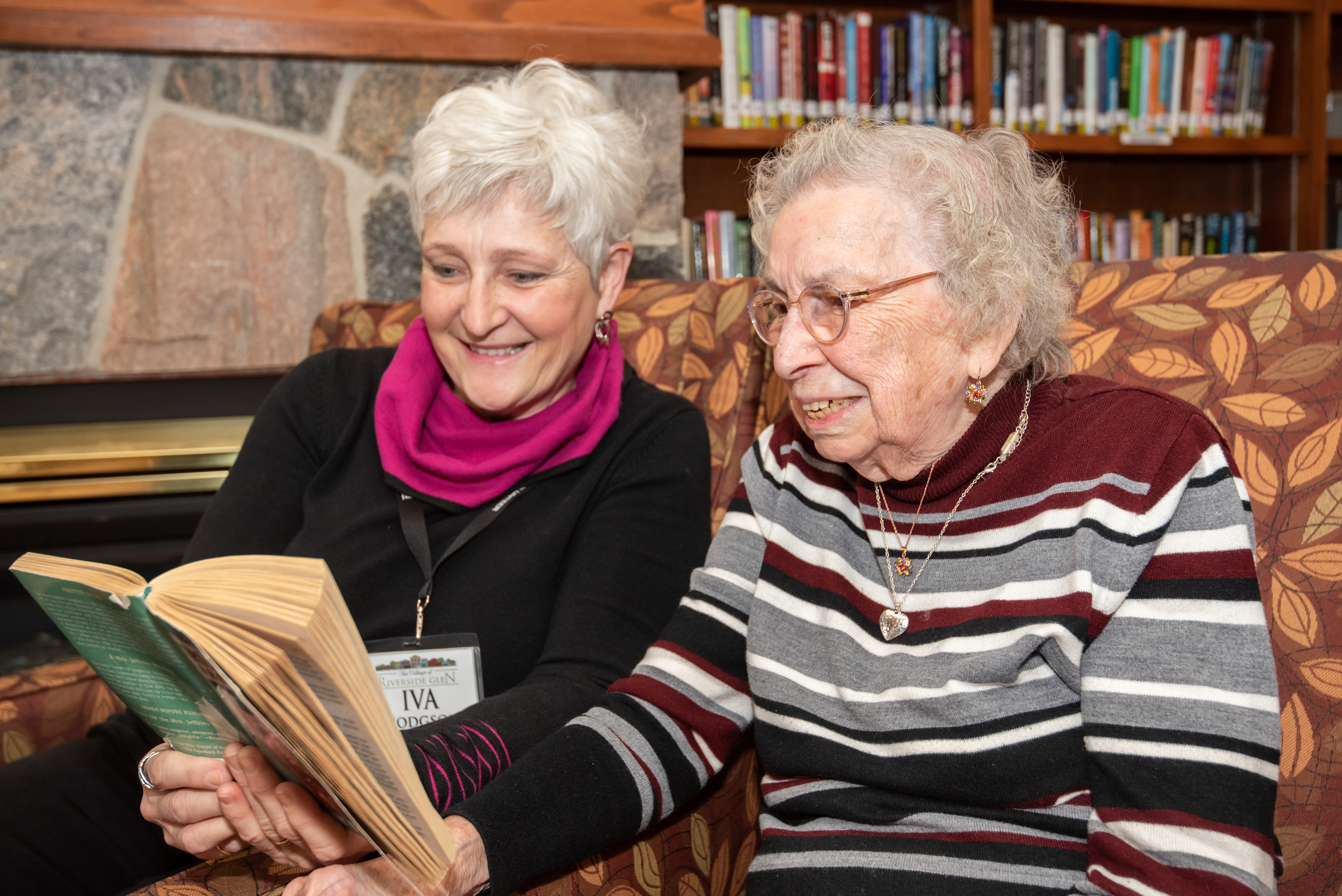 Volunteer reading to a resident in the Library