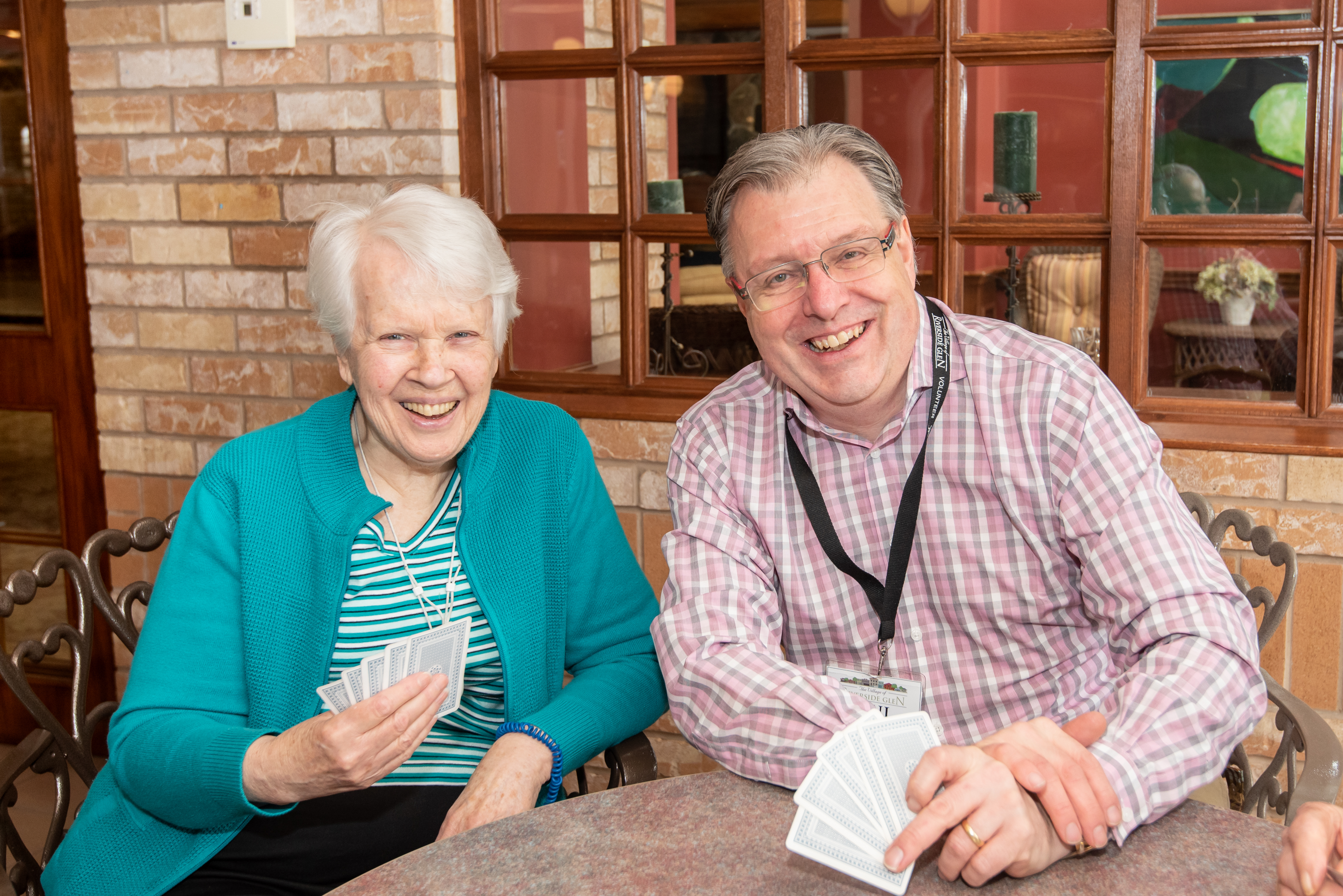 Volunteer playing cards with resident in the cafe