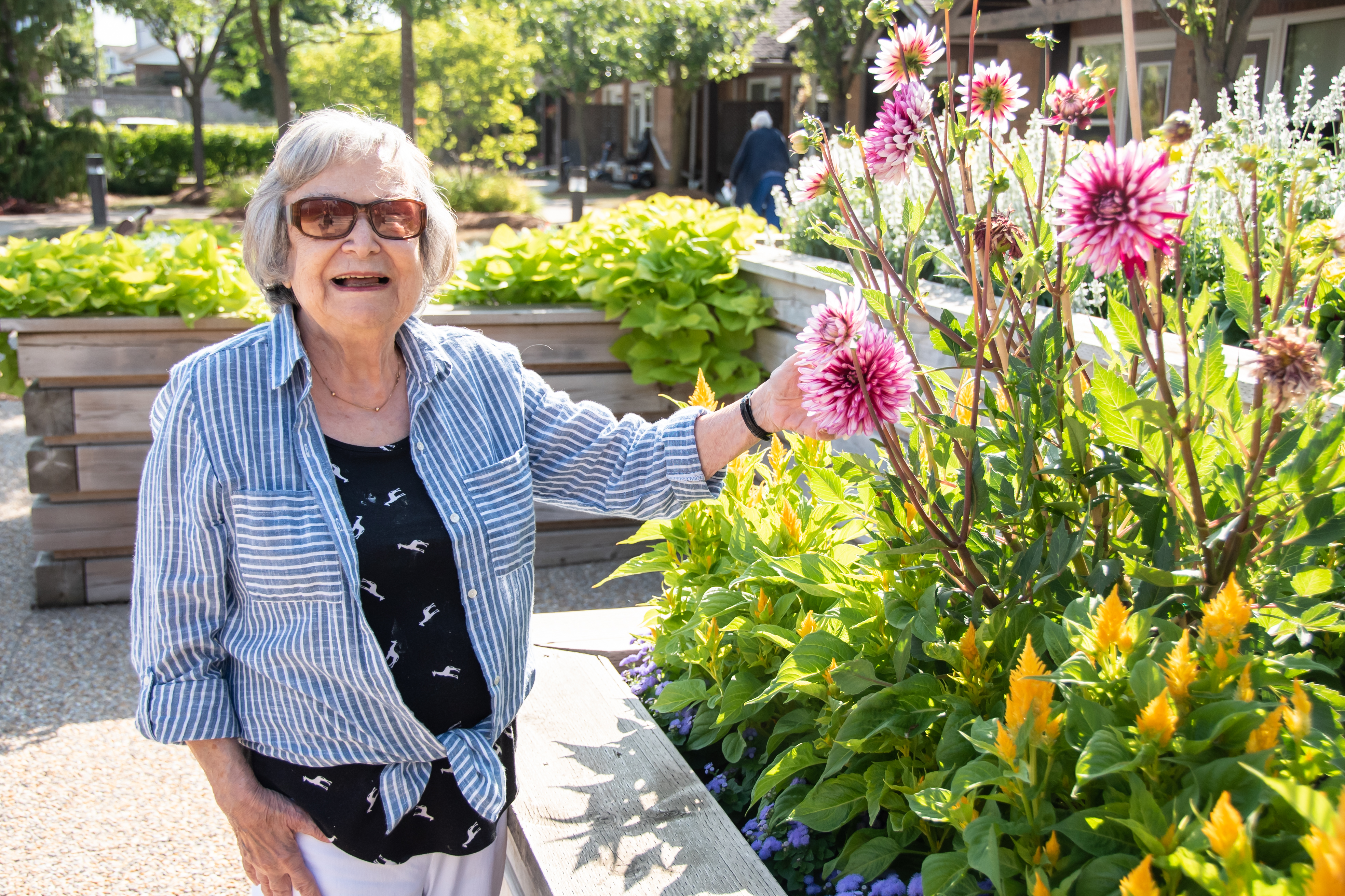 Woman standing with flowers in the raised garden beds