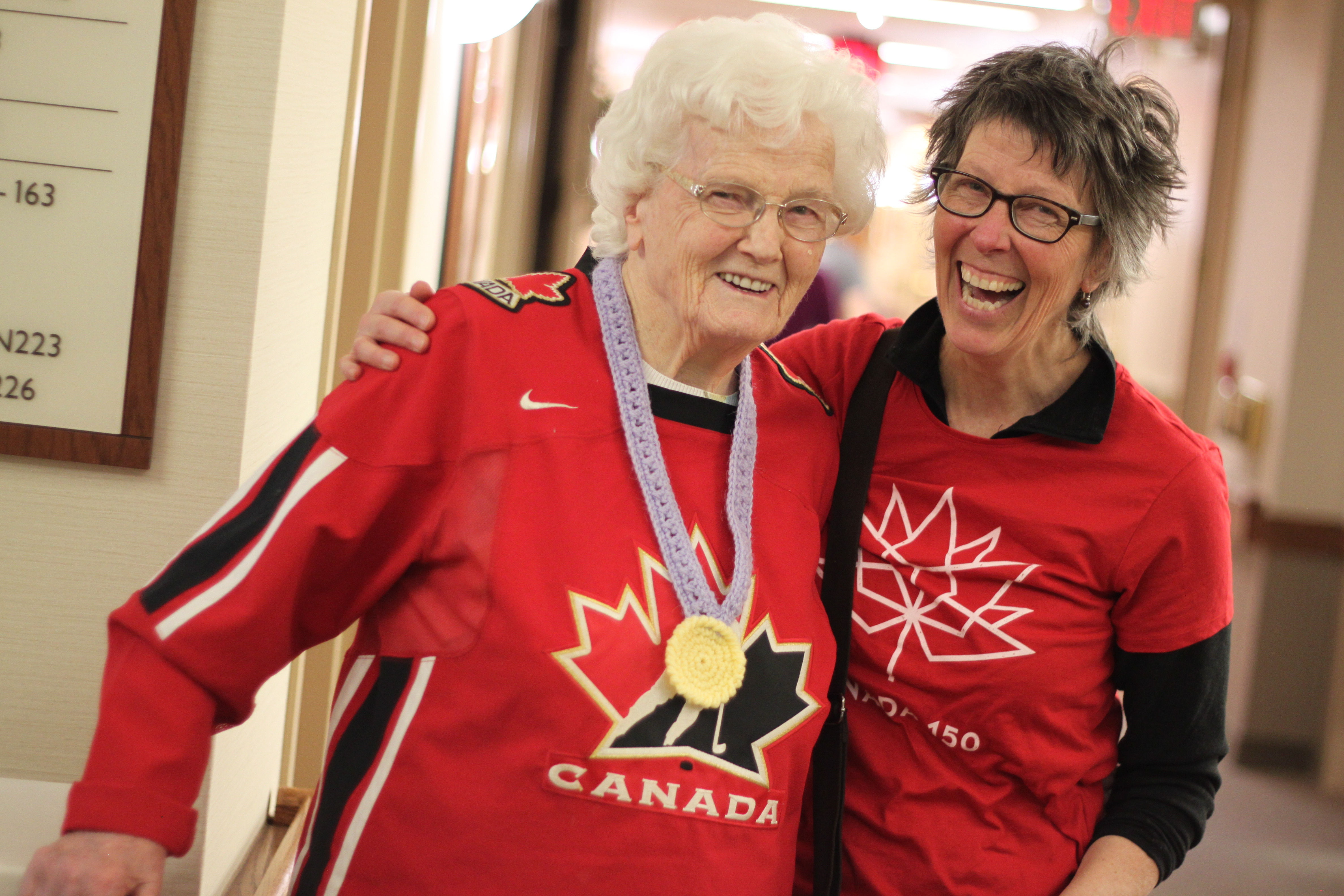 resident along with daughter smile while wearing their Canada Olympic shirts