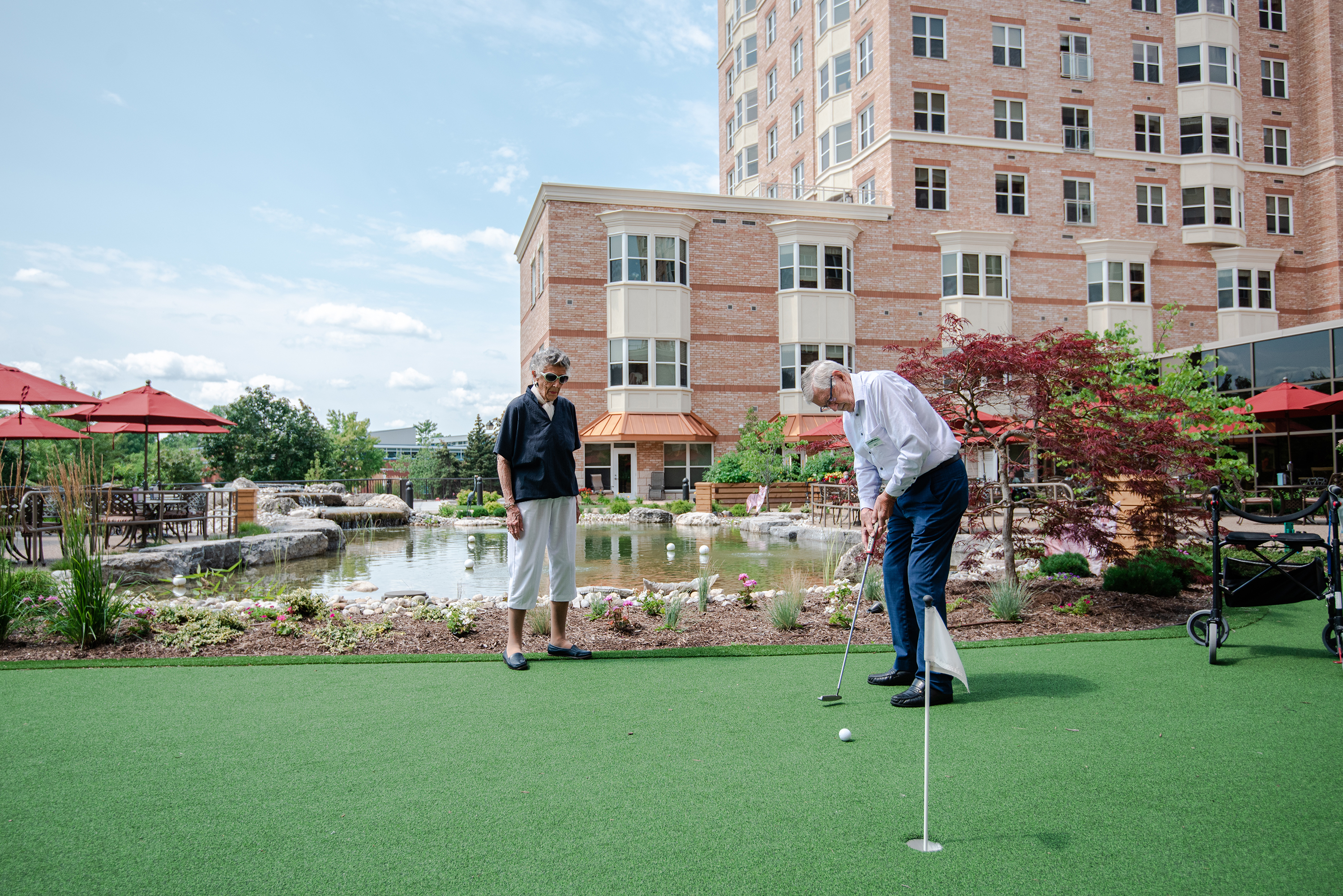 Two residents putting on the golf green in the Courtyard
