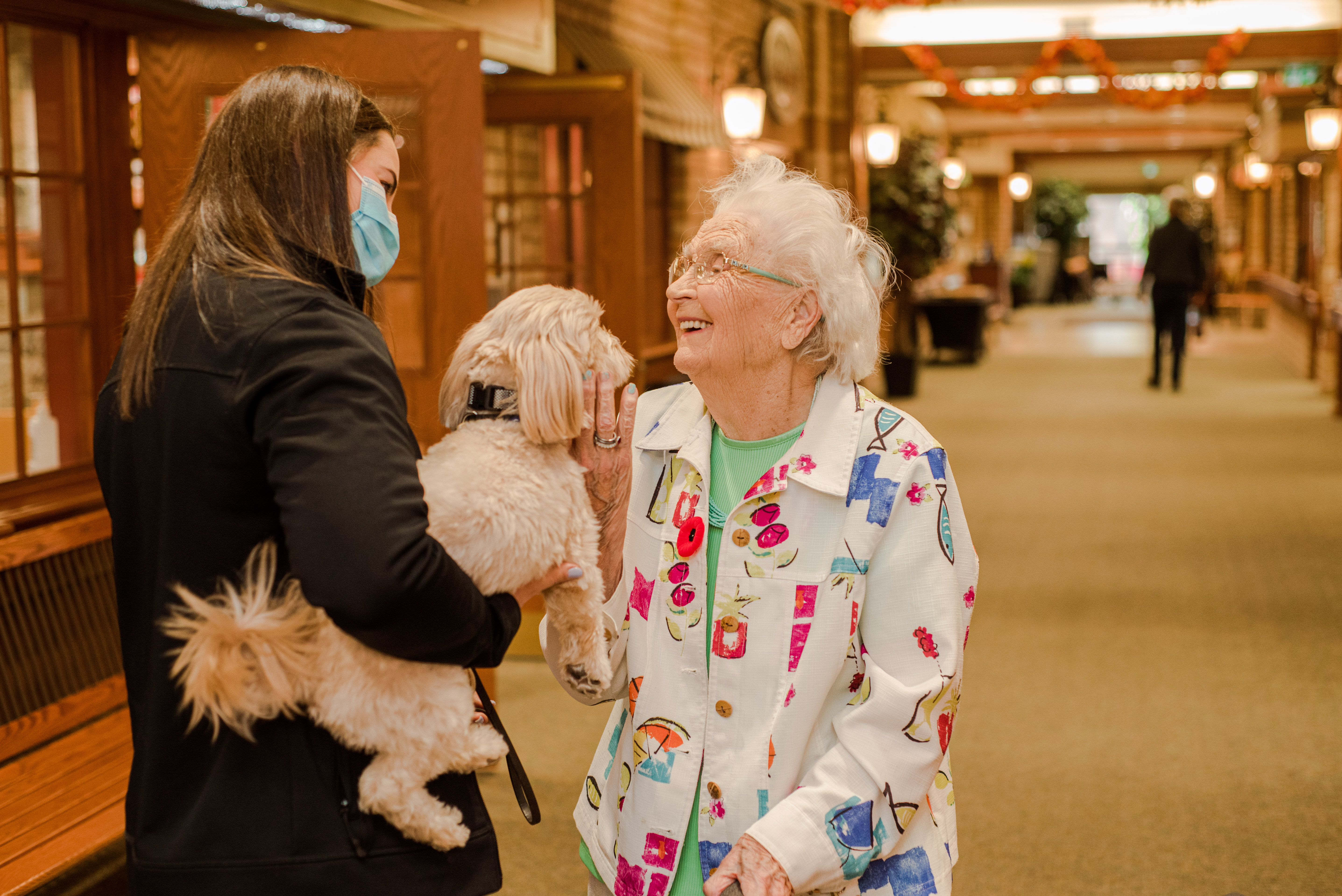 Schlegel Villages team member introducing a puppy to a senior on main street