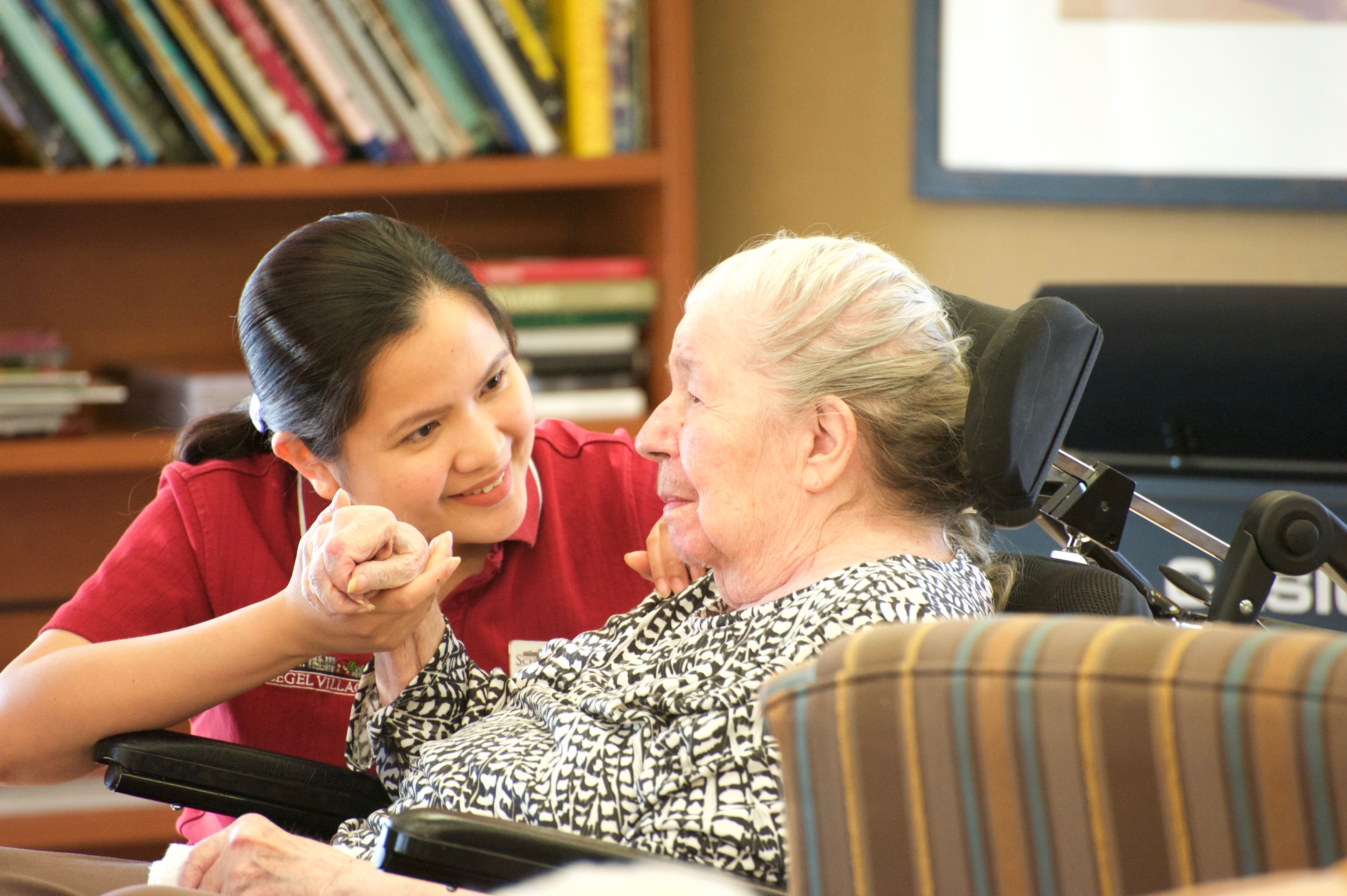 Team member chatting with a resident in a wheelchair