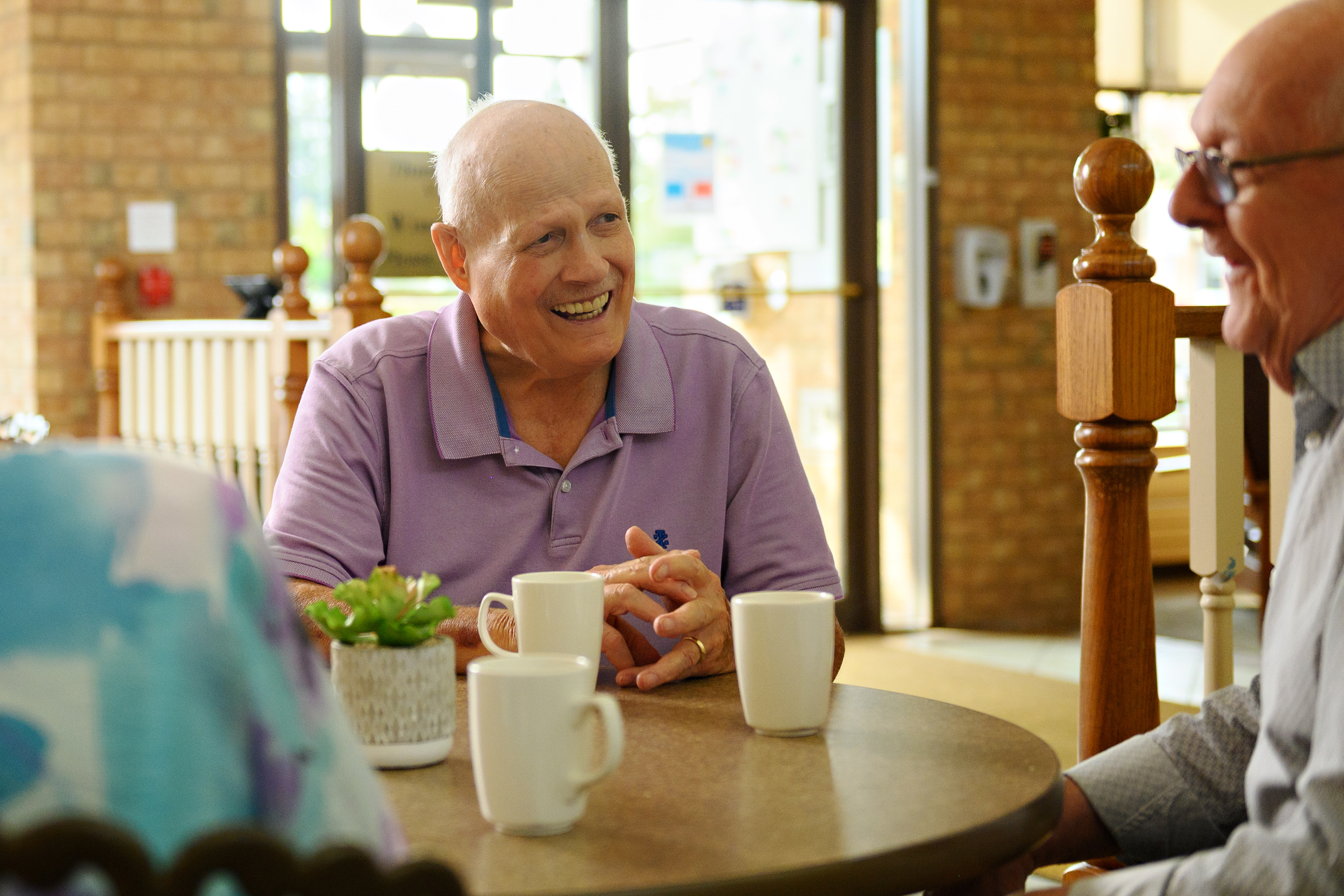 Ron Schlegel, for whom the RSU education platform for team members was named, sits in conversation with residents at The Village of Winston Park. 