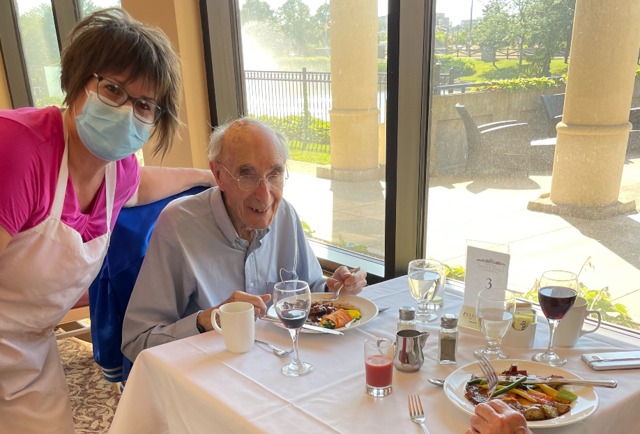 Woman serves meal to senior man in the dining room