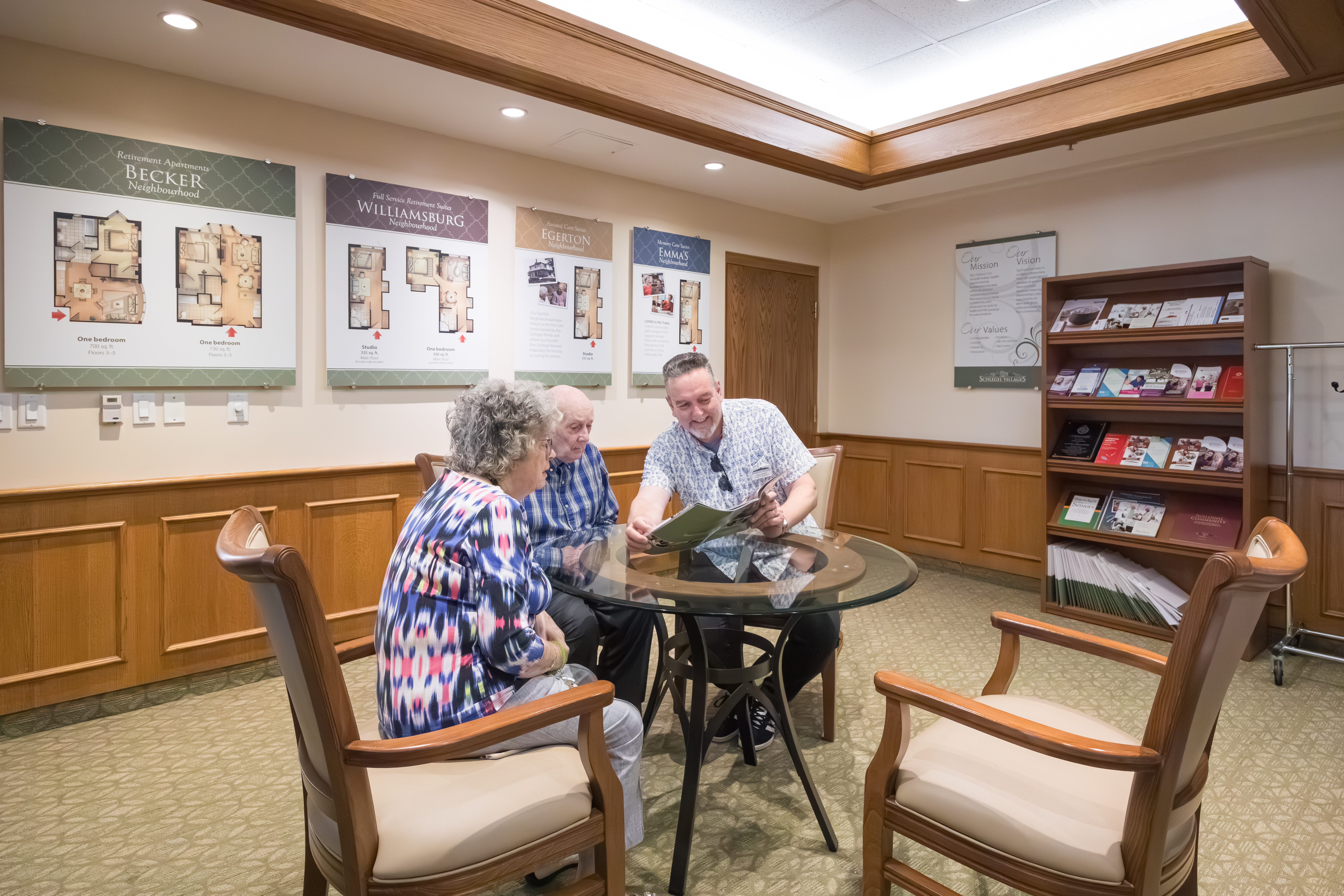 Seniors visit with Director of Lifestyle Options in the Welcome Centre at The Village of Humber Heights