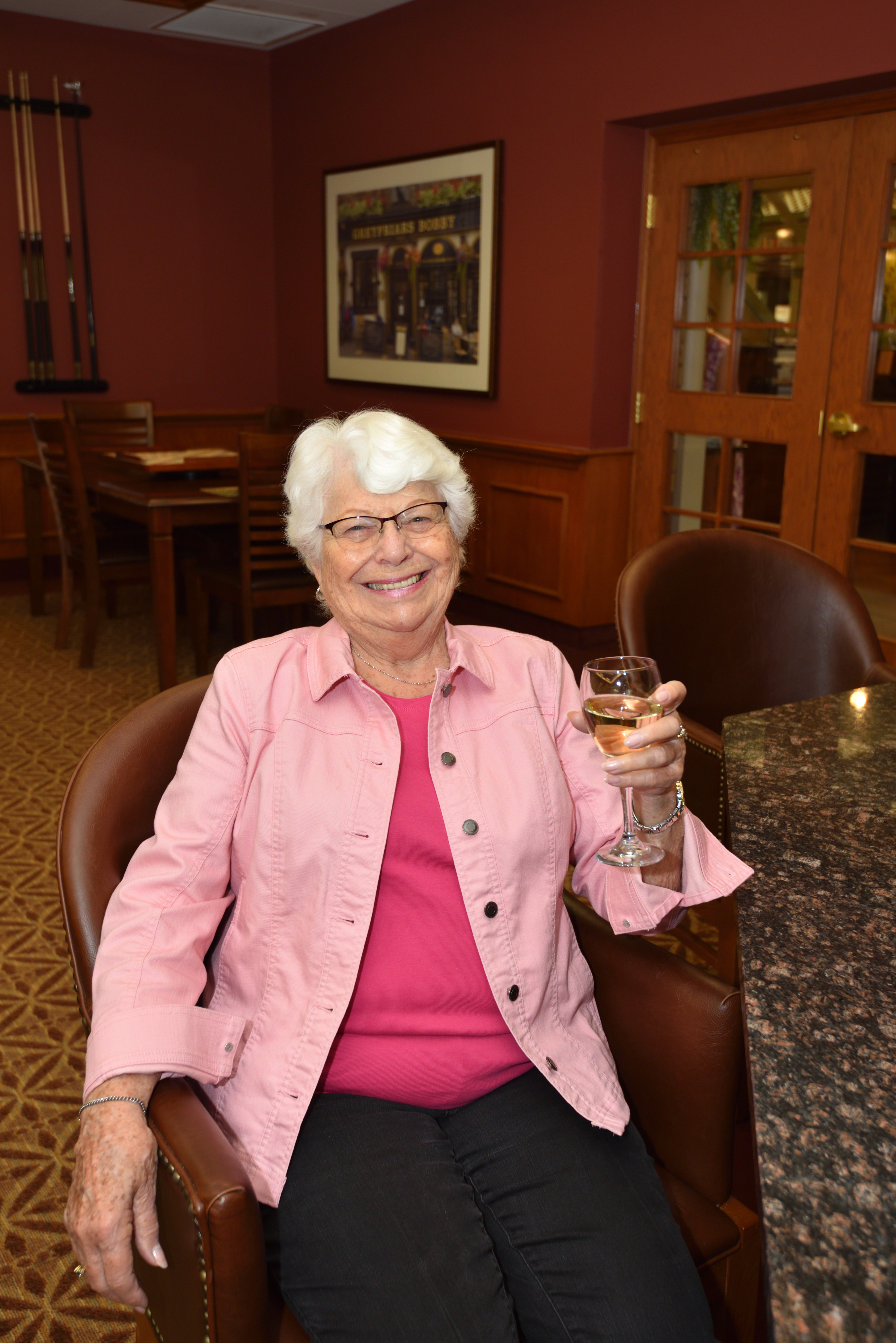 Resident drinking a glass of wine at happy hour in the Social Club