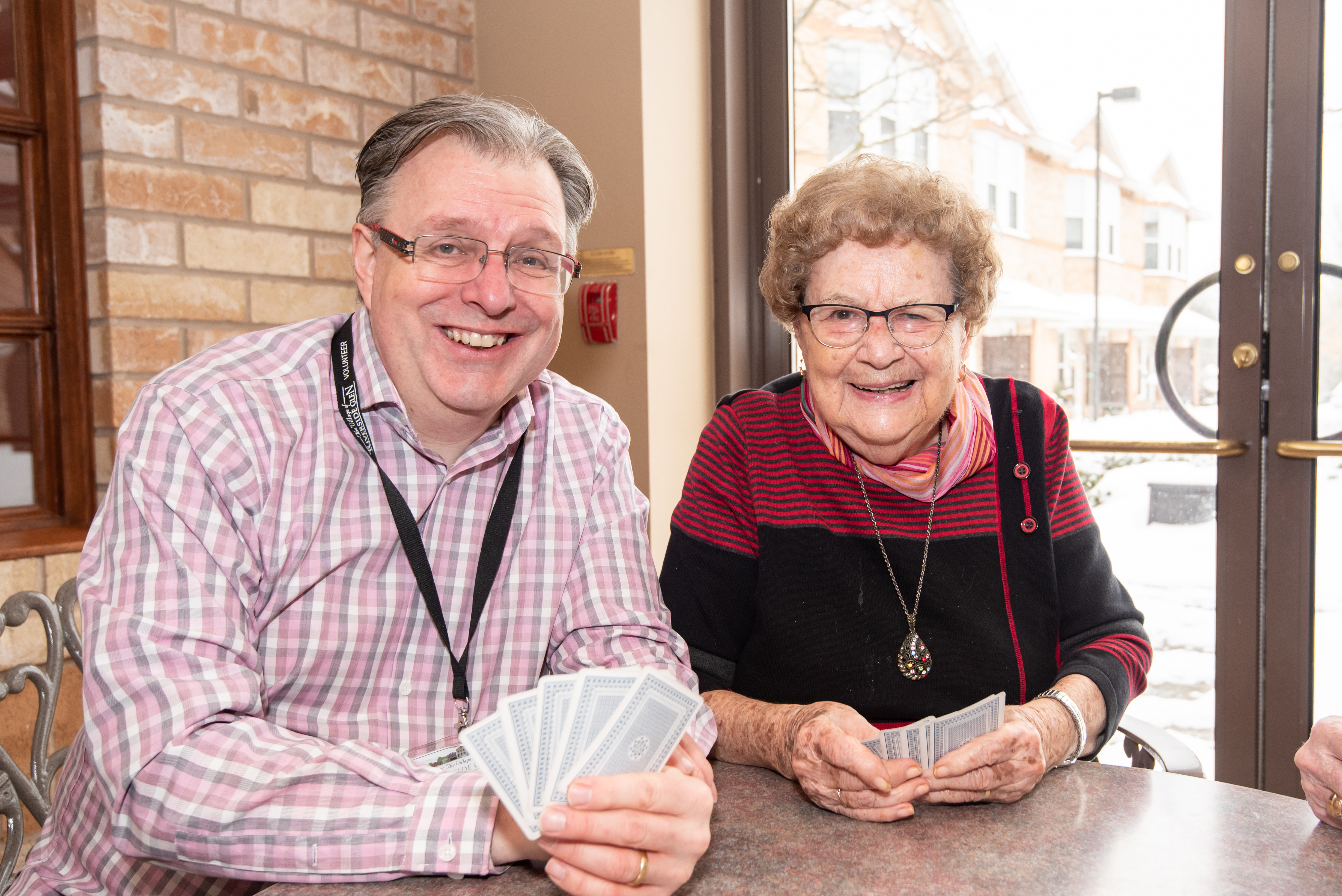 Volunteer and resident playing cards in the Cafe