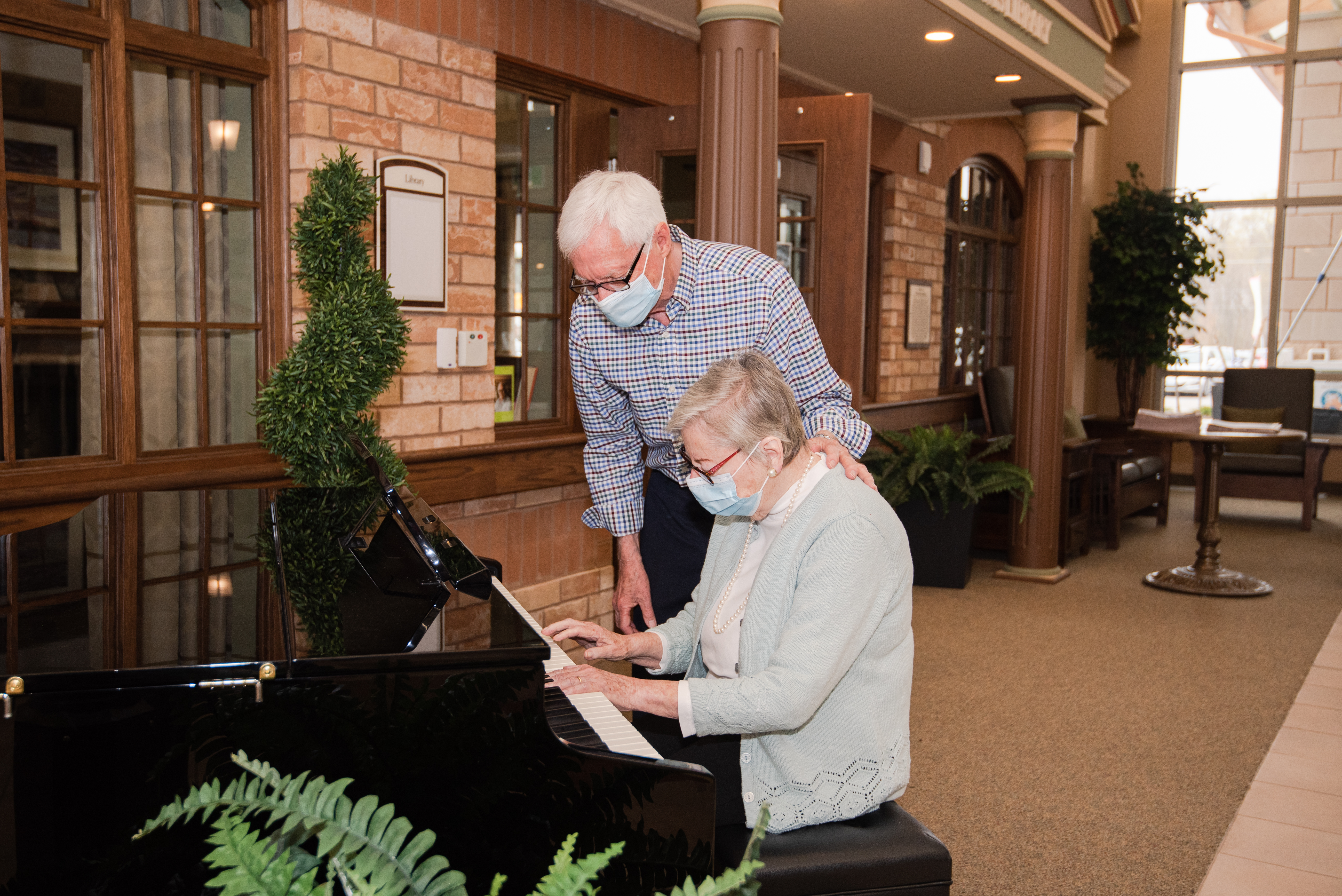 Resident playing the piano on Main Street while husband watches