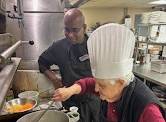 Angelica and Nimal, the chef at the Ruby, stand over a pot of sauce while preparing her guest chef meal. 