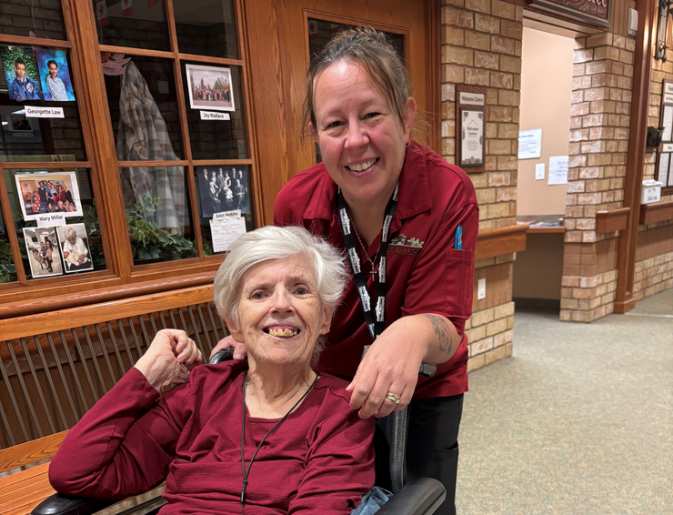 Julie poses with a Wentworth Heights resident, each with wide grins upon their faces. 
