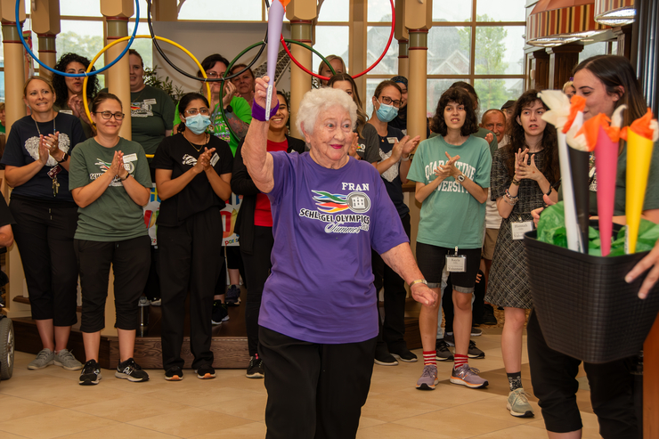 Resident carries the Torch at the Schlegel Olympics