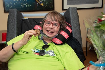 Melody from Erin Mills Lodge shows her Gold Medal in the Olympic Shooting event