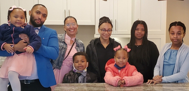 Chantal and her husband stand alongside the children they have helped support through tragic times.