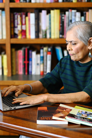 Jasmine typing on a laptop with her books