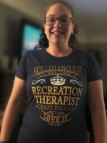 Emily with a shirt that says "Skilled enough to be a recreation therapist, crazy enough to love it!"