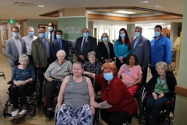 Residents pose with dignitaries during a visit to the new Village of Winston Park building