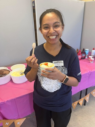 Jeanette smiles wide while pictured with an ice cream sundae at a Team Appreciation Event. 