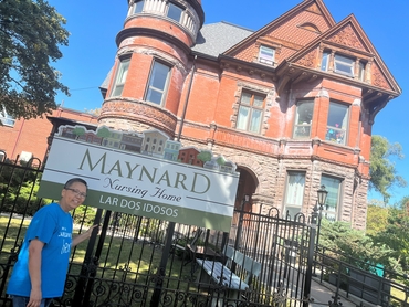 Lou stands in front of the historic building that is Maynard Nursing Home. 