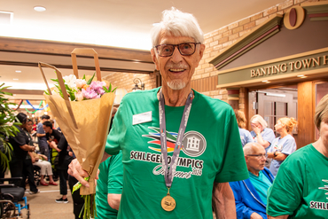 Senior poses with medal and flowers from winning the Schlegel Olympics