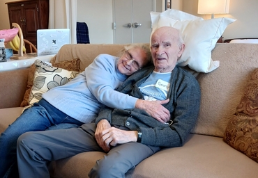Ursula and George cuddle on their sofa in their new home at Winston Park. 
