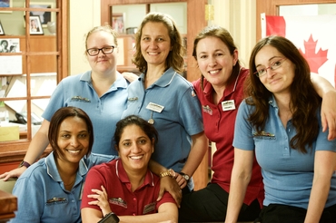 A group of team members pose together in their blue and red Schlegel Villages uniforms. 