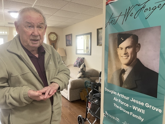Doug is pictured in his Arbour Trails suite beside a banner that honoured the service of his late father in The Second World War. 