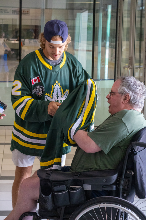 One of the players with the Elmira Sugar Kings presents a new jersey to Tom as a gift. 