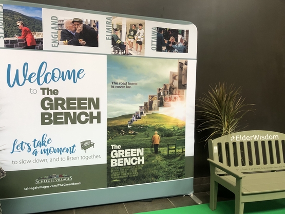 A green bench display featuring photos of the stars and the movie poster rests alongside one of the iconic Green Benches. 