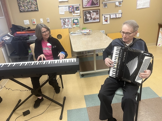 Henry plays the accordion accompanied by music therapist Melissa Jessop on piano. 