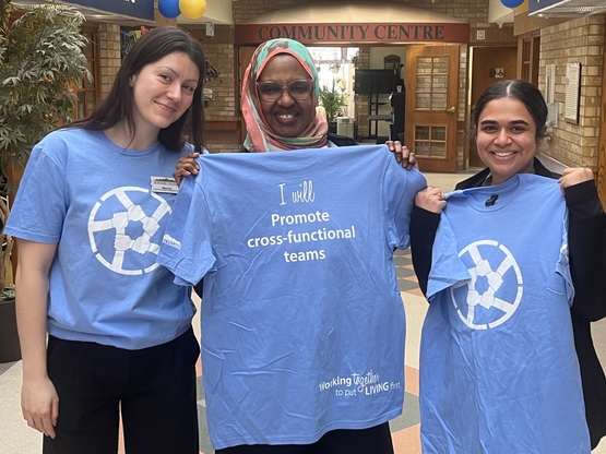 Team members from The Village of Erin Meadows show of their new aspiration T-Shirts, committing to promoting cross-functional teams. 