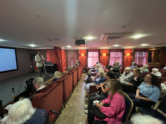 Film producer Ted Hudson speaks to the audience before the film screening at Maycroft Manor. 