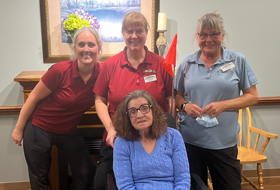 Kay poses with three neighbourhood team members in her home at The Village of Aspen Lake. 