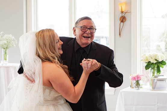 Jillian and her father, Louis, smile brightly as they dance together at her wedding. 