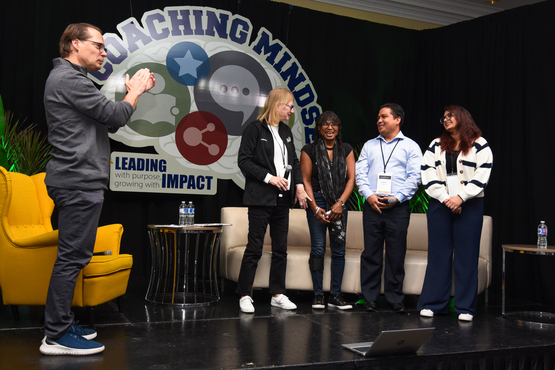 Jamie Schlegel stands upon the stage at the annual leadership retreat and applauds the four panelists, Kim, Hilda, Vergel and Jashan.