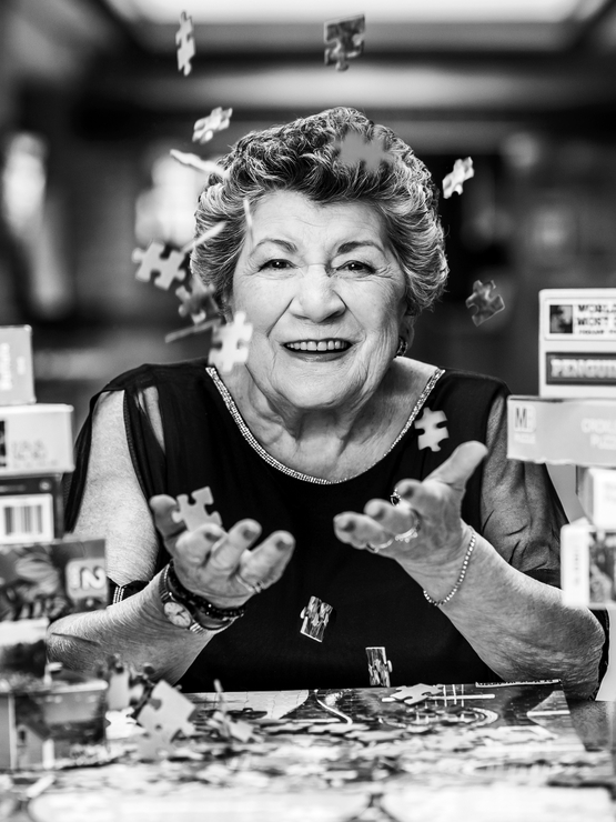 Marie Henderson black and white portrait with puzzle pieces falling