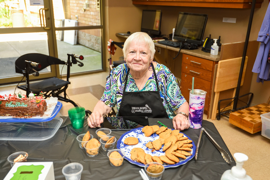 A lovely resident sits before the tray of cookies she made for the testing event.