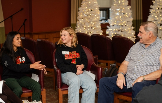 Two young SHSM student share conversation with a Tansley Woods resident. 