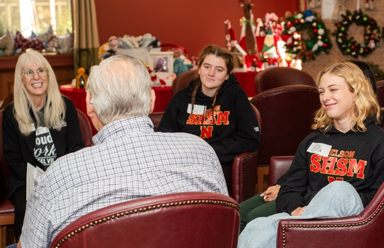 High School SHSM students and a Tansley Woods team member gather before a Village resident to hear about life in the Village.