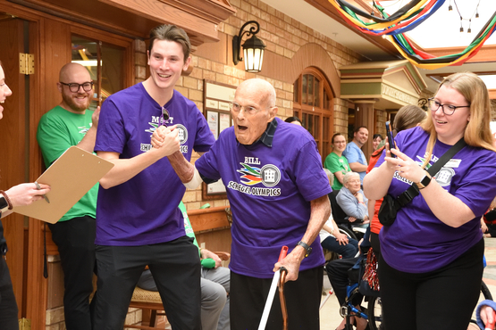 Team members connect with a resident at the Schlegel Olympics, where everyone comes together in support of residents. 