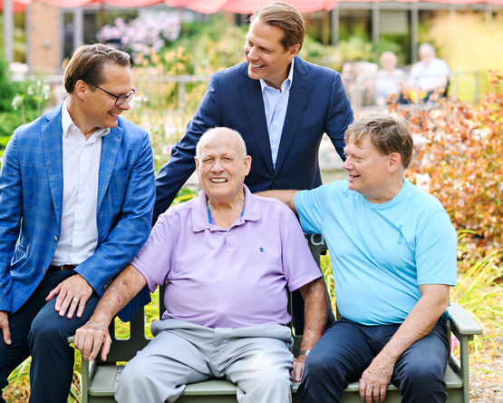 Ron Schlegel sits upon the iconic Green Bench with his three sons, Rob, Brad and Jamie. 