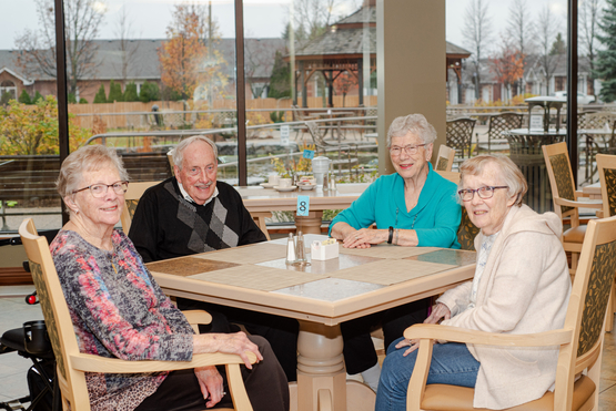 Long-time friends Anne, Gord, Gloria and Doreen gather around the table in the dining room at Taunton Mills. 