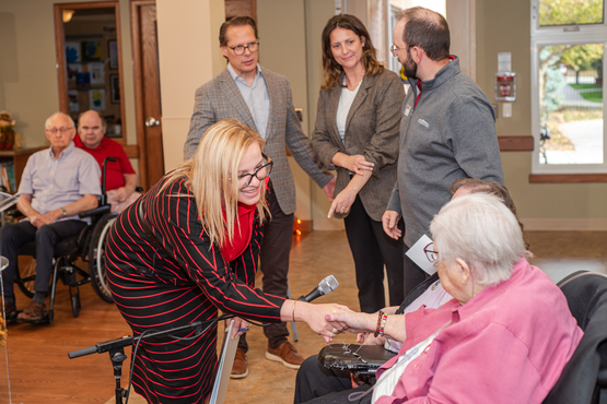 The minister greets Winston Park's Residents' Council president, Jackie Papke.