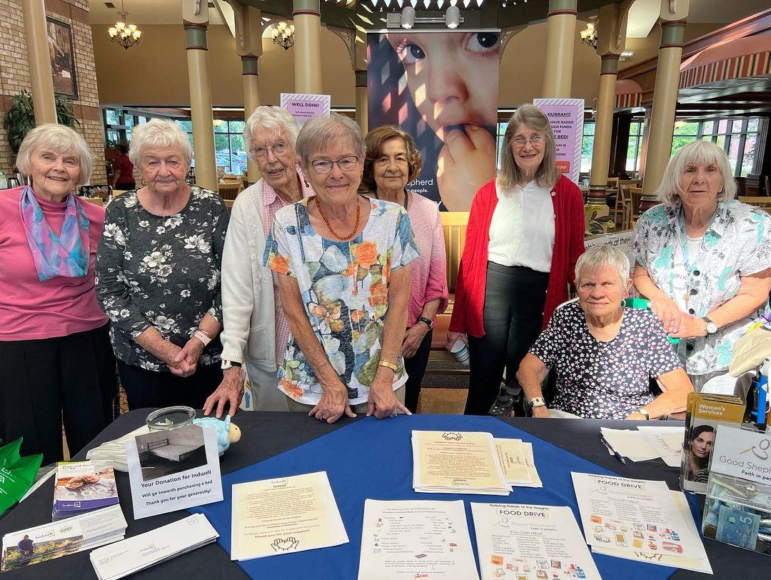 A group of Wentworth Heights residents gather around an information table as they raise funds in the Village to combat homelessness in Hamilton.