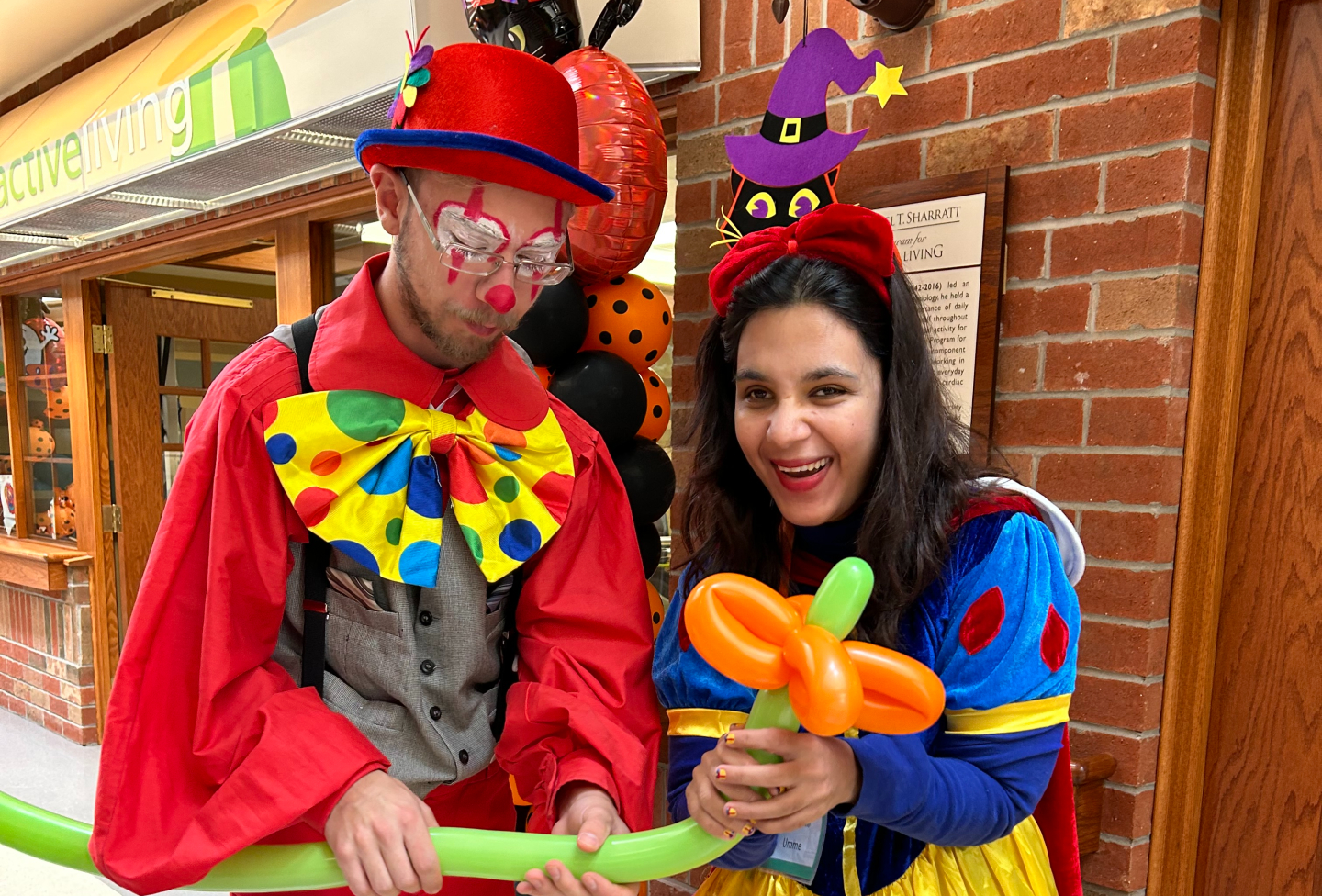 On Halloween, Umme is dressed as a colourful Disney princess alongside another St. Clair team Member dressed as a clown.
